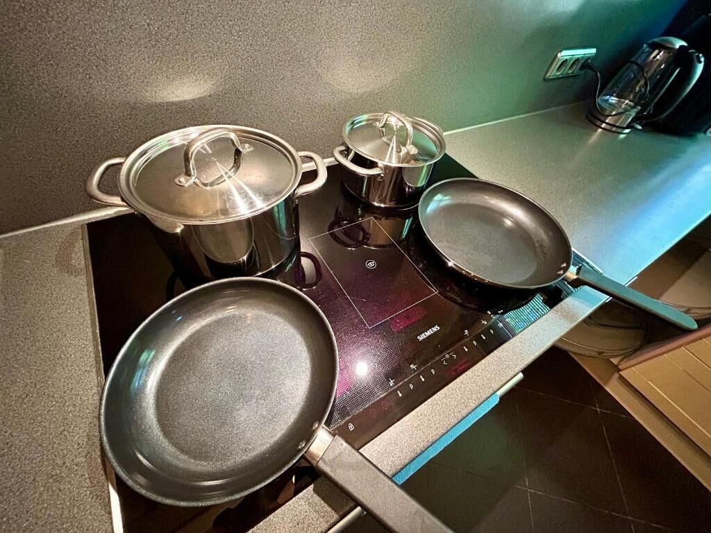 Eine Küche mit Herd, Töpfen und Pfannen.
