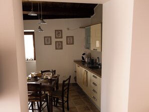 A kitchen with a dining table, chairs, a sink, and a window.