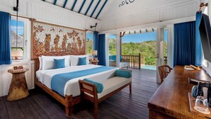 A bedroom with a large bed, a wooden desk, and a view of a swimming pool. - Emana Aruna (Penida Island)