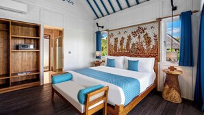 A bedroom with a large bed, a wooden bench, a wardrobe, and a decorative tapestry. - Emana Aruna (Penida Island)