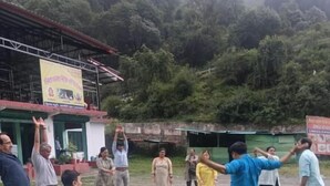 Un grupo de personas al aire libre en un área con césped, con un edificio al fondo.