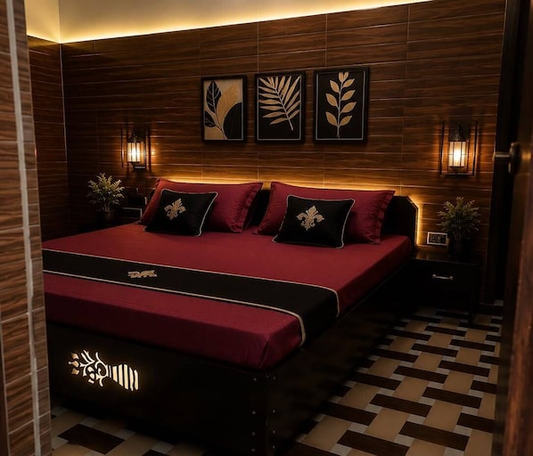 A modern bedroom with a large bed, dark wood paneling, wall-mounted artwork, and bedside lamps.