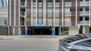 Un estacionamiento de varios pisos con una decoración azul y blanca, que muestra un letrero 'SÓLO SALIDA' y un letrero 'ESTACIONAMIENTO PÚBLICO'.