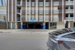 Eine mehrstöckige Parkgarage mit blau-weißer Gestaltung, mit einem 'EXIT ONLY'-Schild und einem 'PUBLIC PARKING'-Schild.