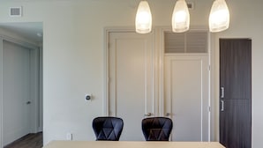 Una habitación con una mesa de comedor, dos sillas, una puerta y un armario.