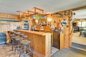 A wooden bar area with a counter, stools, and various bar items. - Lake Champlain Studio: Fish, Play & Relax (Willsboro)