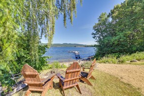 A lakeside view with wooden chairs and a picnic table. - Lake Champlain Studio: Fish, Play & Relax (Willsboro)