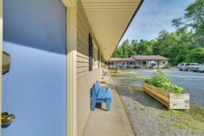 A motel with a covered porch, a blue bench, and a planter with greenery. - Lake Champlain Escape at Willsboro Inn w/ Dock (Willsboro)