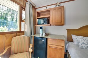 A compact room with a bed, a desk with a microwave, a refrigerator, and a chair. - Lake Champlain Escape at Willsboro Inn w/ Dock (Willsboro)