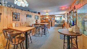 Een gezellig interieur met houten wanden, een bar in het midden en een ronde tafel met stoelen.