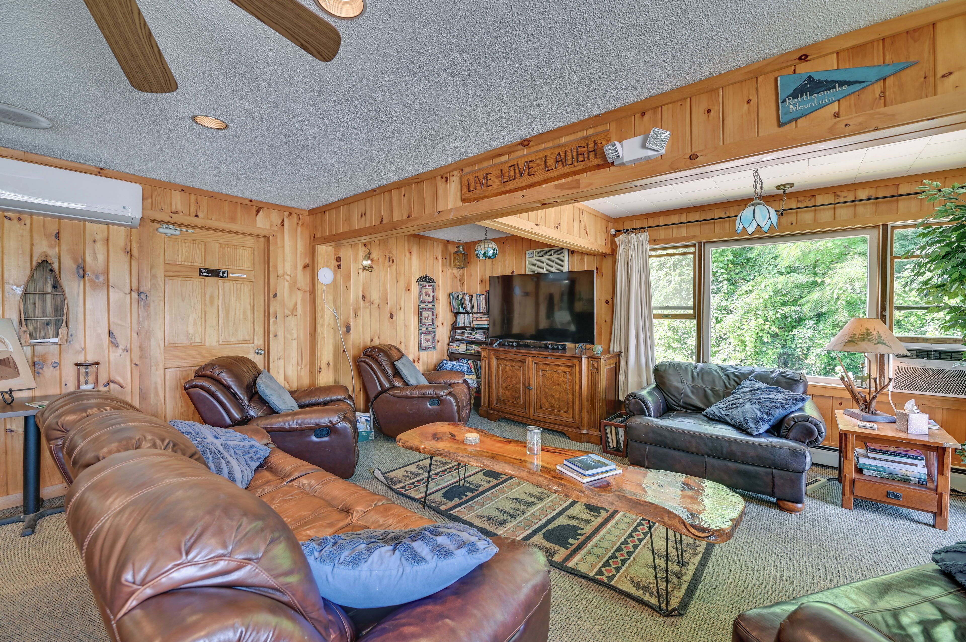 A cozy living room with leather sofas, a coffee table, and a television.