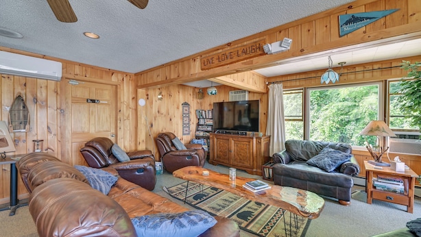 A cozy living room with leather sofas, a coffee table, and a television. - Gather Lakeside at Willsboro Inn on Lake Champlain (Willsboro)