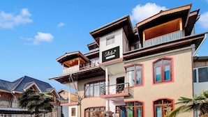 A multi-story building with a prominent 'Collection' sign, balconies, and a mix of windows and doors. - Collection O Brein Nishat (Srinagar)