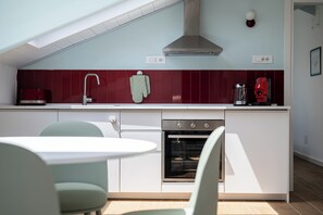 Een moderne keuken met een inbouwoven, een koffiezetapparaat en een handdoek.