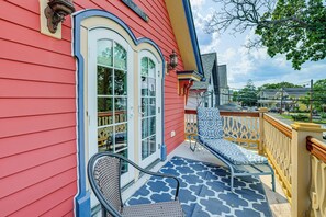 A red building with a balcony featuring two chairs and a patterned floor. - Walkable Victorian Cottage in Historic Ocean Grove (Ocean Grove)