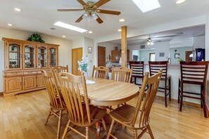A dining area with a wooden table and chairs, a ceiling fan, and a cabinet with glass doors. - Grill & Fenced Yard! Longmont Home, Walk to Parks (Longmont)