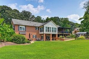 A two-story house with a brick exterior, a covered porch, and a well-maintained lawn. - Shared Fire Pit! Quiet Lake Norman Guest Suite (Mooresville)