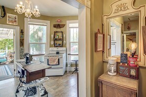 A kitchen with a vintage stove, a coffee maker, and a wooden cabinet. - Walk to Bathhouse Row! Historic Gem w/ Yard (Hot Springs)