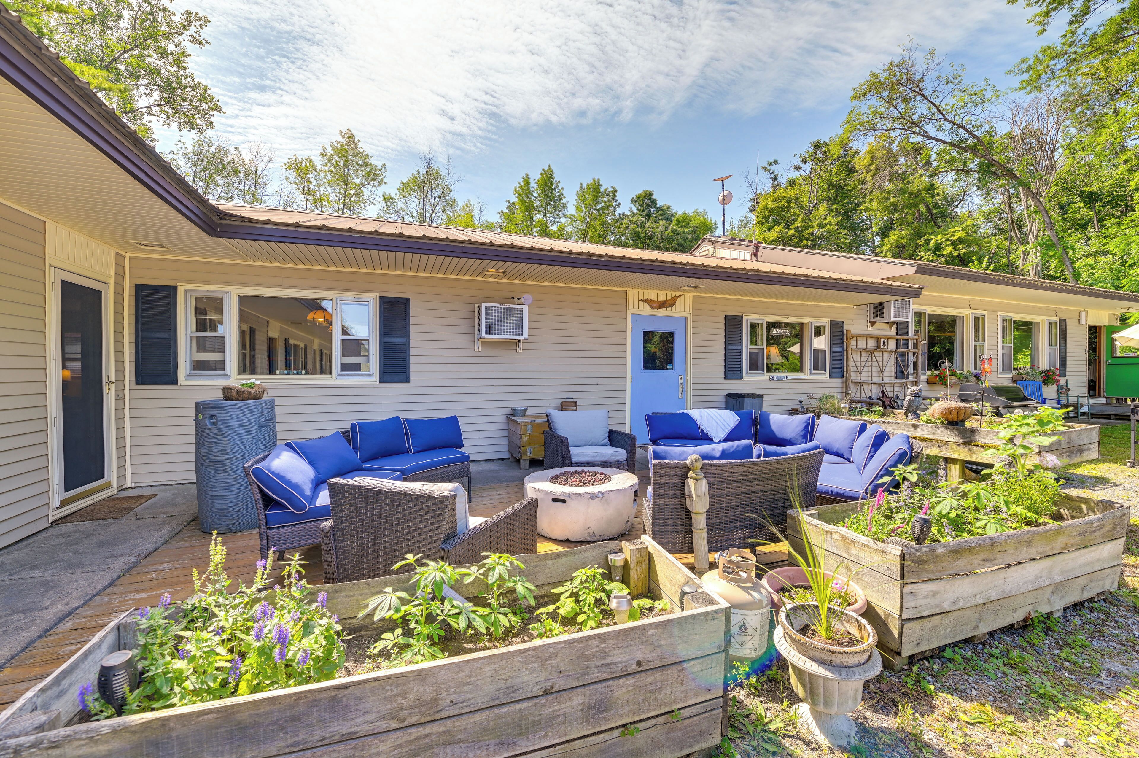 A covered outdoor patio with wicker furniture and raised garden beds.