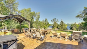 Eine Terrasse im Freien mit Holzboden, Stühlen und Tischen mit Metallgestellen.