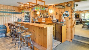 Eine Bar mit Holztresen und Hockern, verziert mit verschiedenen maritimen Elementen.