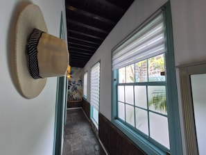 A hallway with a hat on the wall, a staircase, and windows with blinds. - Hacienda de las Indias (Granadilla de Abona)