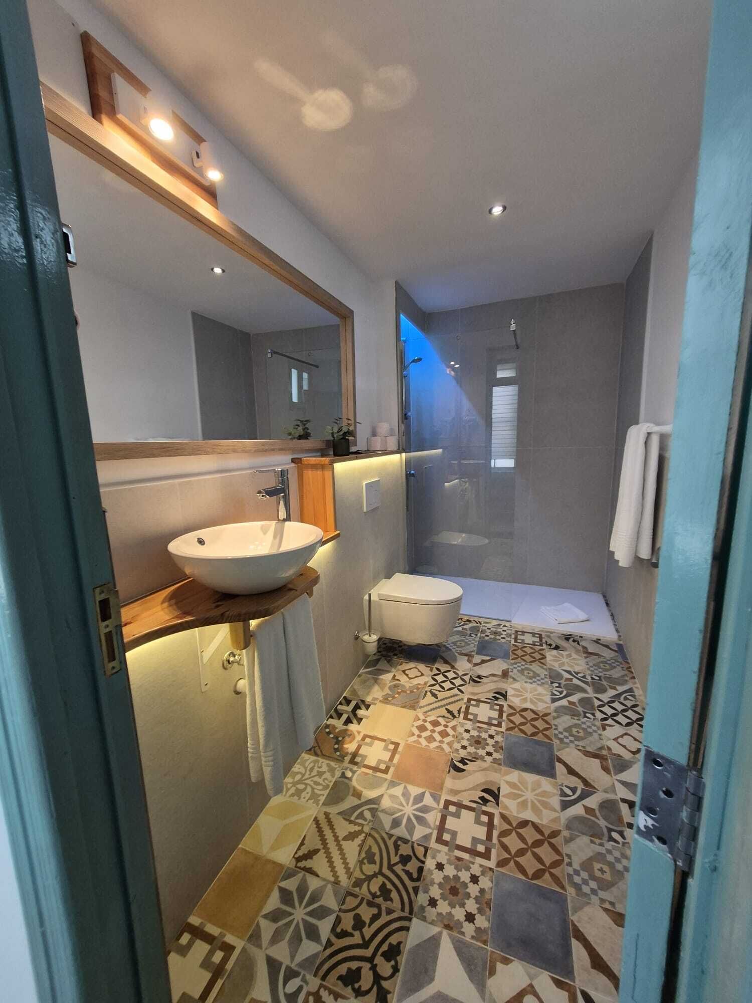 Une salle de bain moderne avec un grand lavabo, des toilettes et un espace douche.