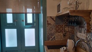 A kitchen with a wooden countertop, a sink, and a microwave.