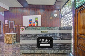 A reception area with a reception desk, a sign indicating 'RECEPTION', and a sign that reads 'Collection Company-Serviced'. - Collection O Kursoo Rajbagh (Srinagar)