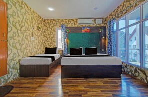 A hotel room with two beds, a green headboard, and large windows. - Collection O Kursoo Rajbagh (Srinagar)