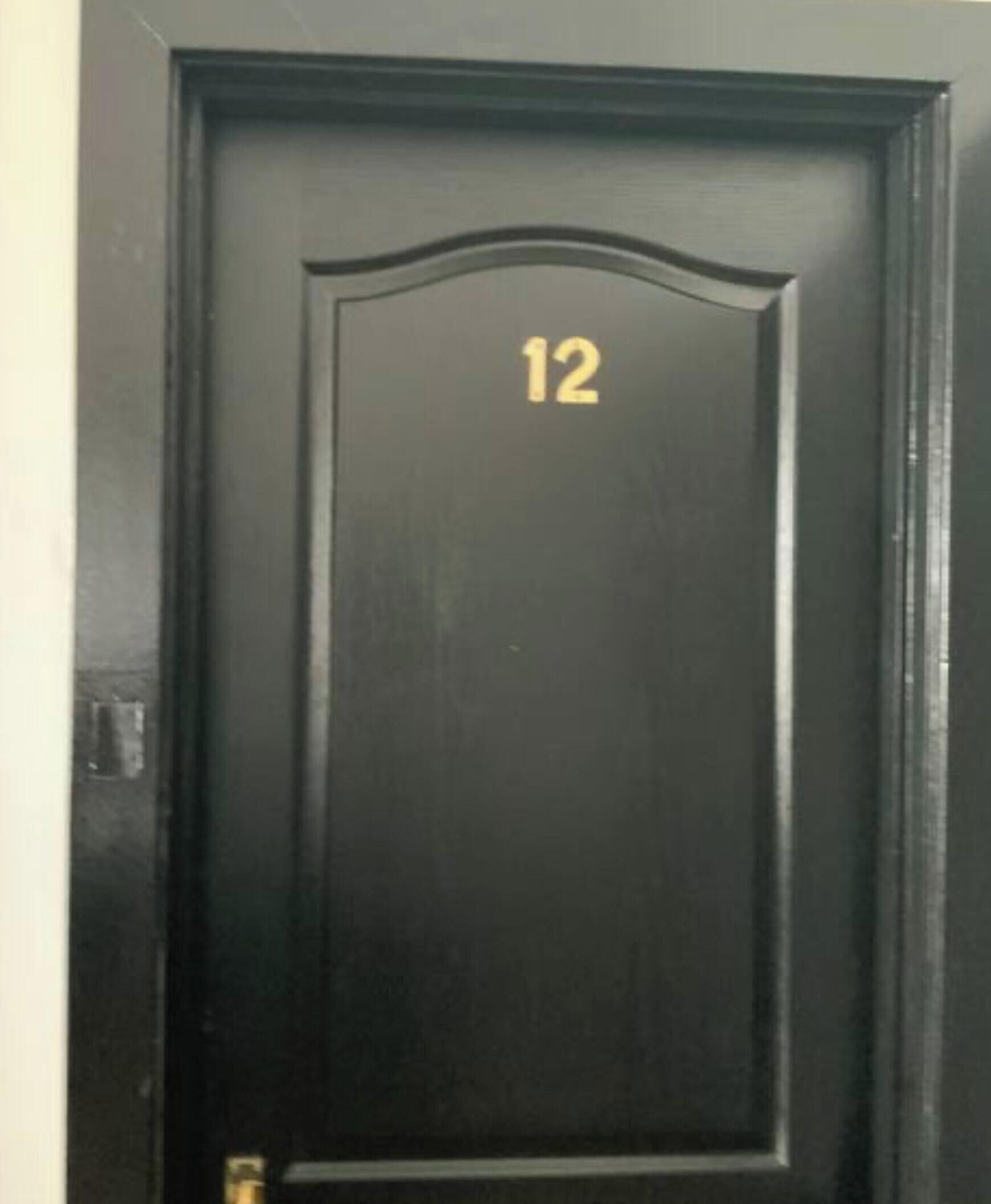 A dark wooden door with the number 12 on it.