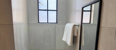 A bathroom with a toilet, sink, and a window.