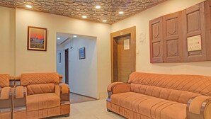 A reception area with a wooden door, a wall-mounted light switch, and a framed picture on the wall. - Collection O NIT Srinagar (Srinagar)