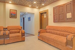 A reception area with a wooden door, a wall-mounted light switch, and a framed picture on the wall. - Collection O NIT Srinagar (Srinagar)