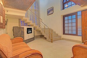 A hotel lobby with a marble reception desk, a staircase, and a large window. - Collection O NIT Srinagar (Srinagar)
