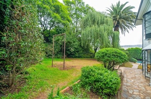 Un jardín con un columpio, un camino de piedra y un césped bien cuidado.