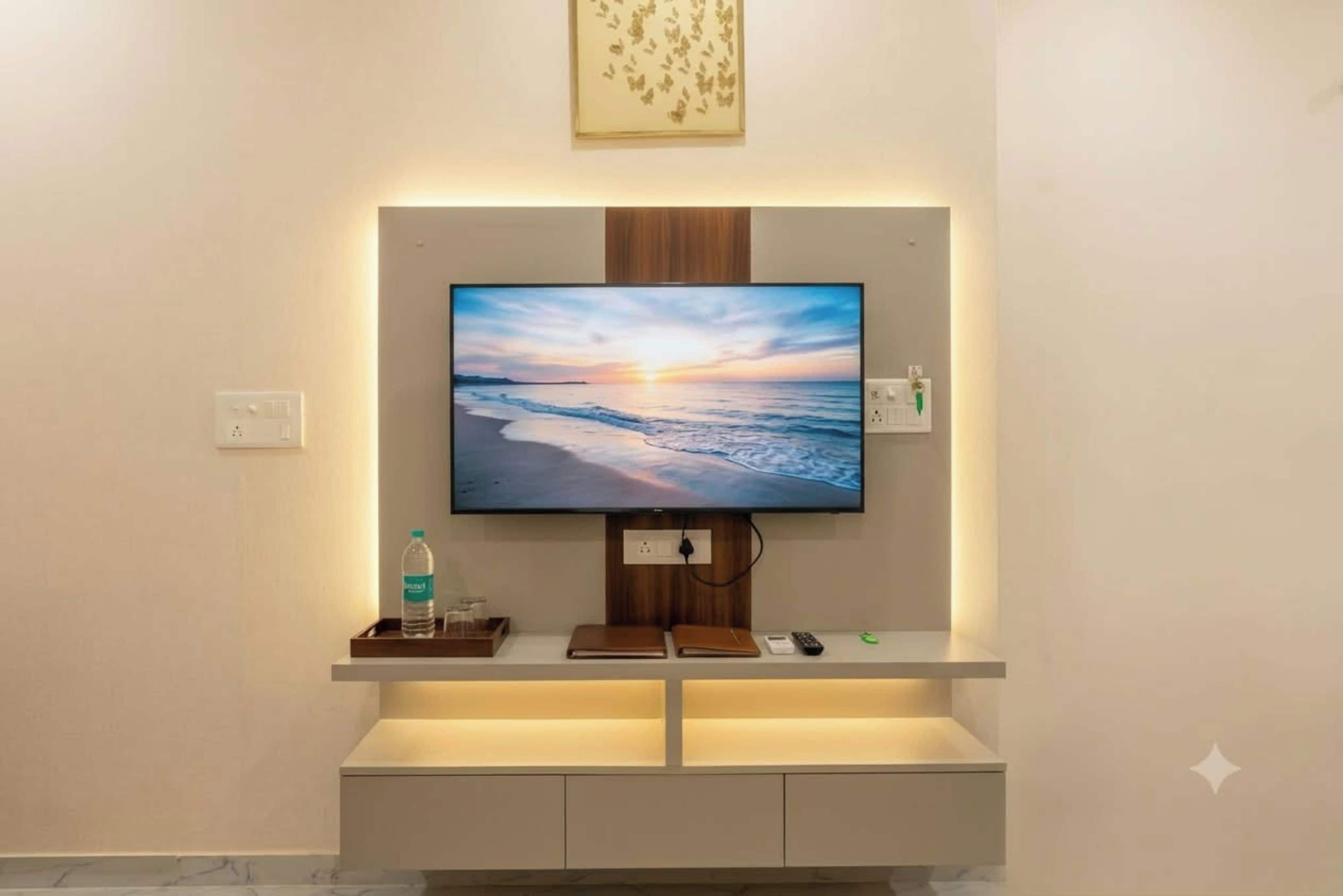 Un televisor de pantalla plana montado en la pared, con un panel de madera encima.
