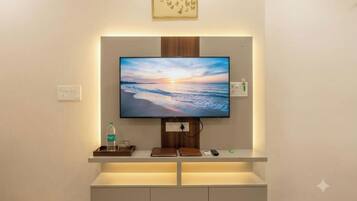 Un televisor de pantalla plana montado en la pared, con un panel de madera encima.