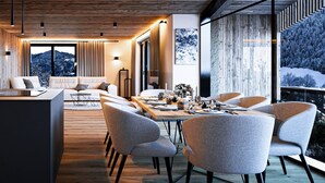 Ein modernes Interieur mit Essbereich, Sofas und Blick auf verschneite Berge.