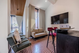 Una sala moderna con un sofá, una silla, un televisor y un suelo con diseño.