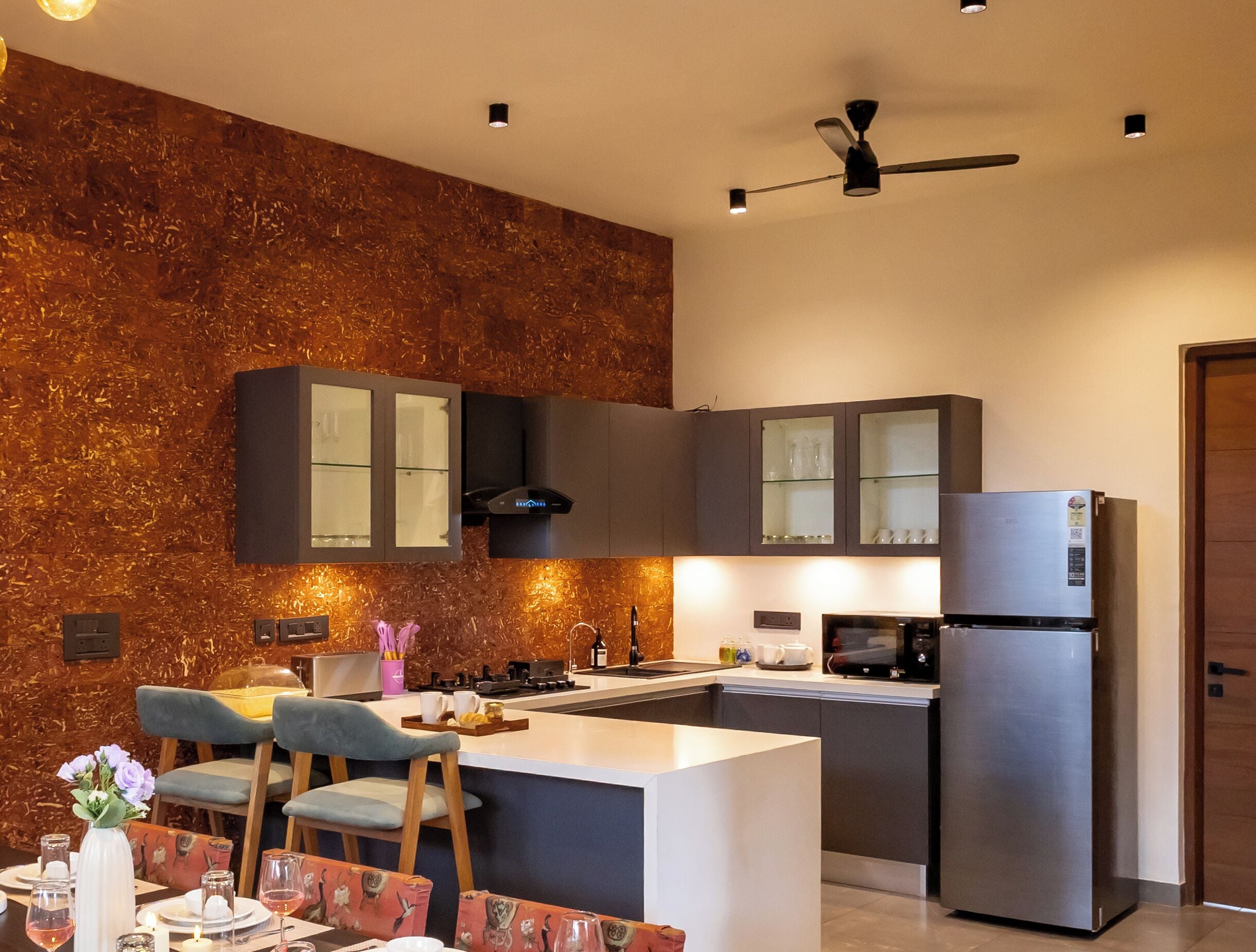 Una cocina moderna con una isla central, armarios empotrados y un refrigerador de acero inoxidable.