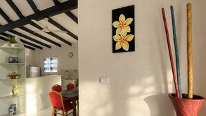 Un coin repas comprenant une table et des chaises, un ventilateur de plafond et un tableau accroché au mur.