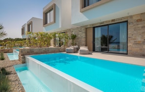 A modern poolside area with a rectangular pool, stone walls, and outdoor seating. - Beautiful home in Tkon (Tkon)