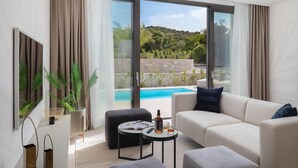 A modern living room with a sofa, a coffee table, and a view of a swimming pool. - Beautiful home in Tkon (Tkon)