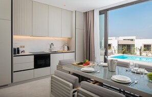 A modern kitchen with a dining area, a pool view, and a built-in oven. - Beautiful home in Tkon (Tkon)