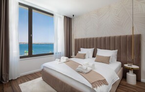 Ein Hotelzimmer mit einem großen Bett, Meerblick und modernem Design.