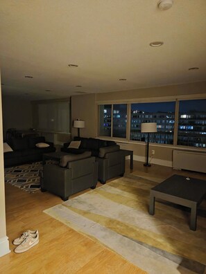 A modern living room with a sofa set, a coffee table, and a lamp.