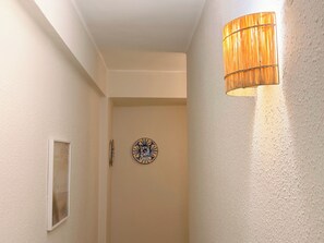A hallway with a textured wall, a door with a frosted glass panel, and a wall-mounted clock. - La Palmera - Amazing beachfront terrace (Cullera)