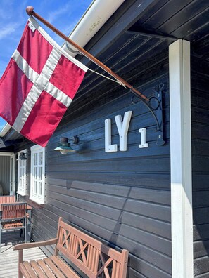 Ein Gebäude mit dunkler Außenfassade, einer Flagge und den Buchstaben 'LY' an der Wand.