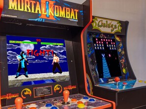 Zwei Spielautomaten mit Mortal Kombat-Branding, die einen Charakter namens Liu Kang und eine Kampfspiel-Oberfläche zeigen.